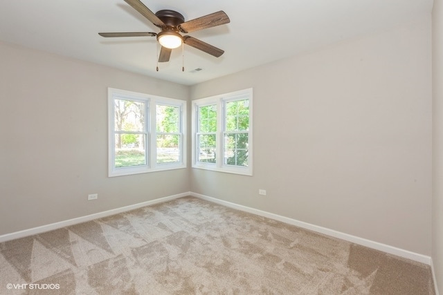 carpeted spare room featuring ceiling fan