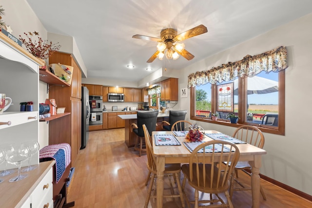 dining room with a ceiling fan, light wood-type flooring, and baseboards