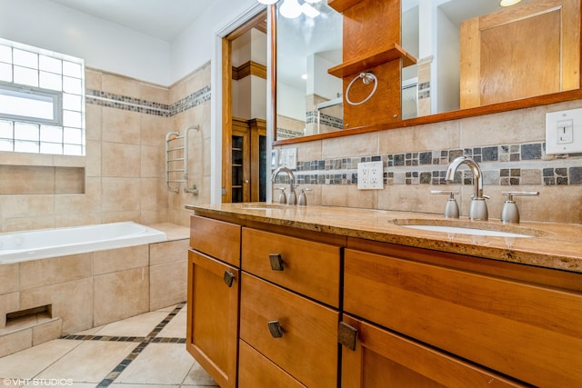 bathroom featuring decorative backsplash, tiled tub, vanity, and tile patterned flooring