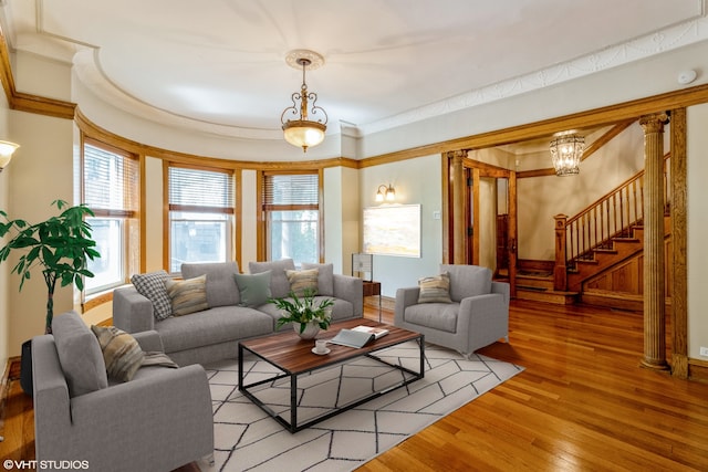 living room featuring ornamental molding, light wood-type flooring, and a chandelier