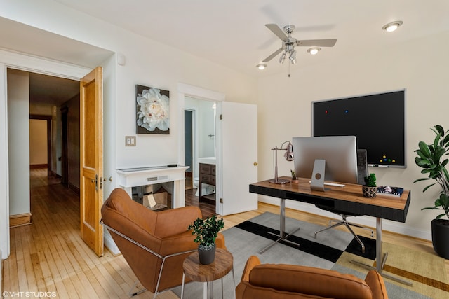 office with ceiling fan and light hardwood / wood-style flooring