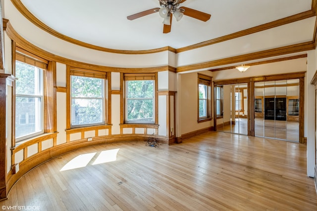 unfurnished living room with light hardwood / wood-style floors, ornamental molding, and ceiling fan