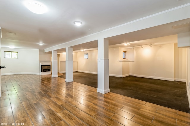 basement with hardwood / wood-style floors and track lighting