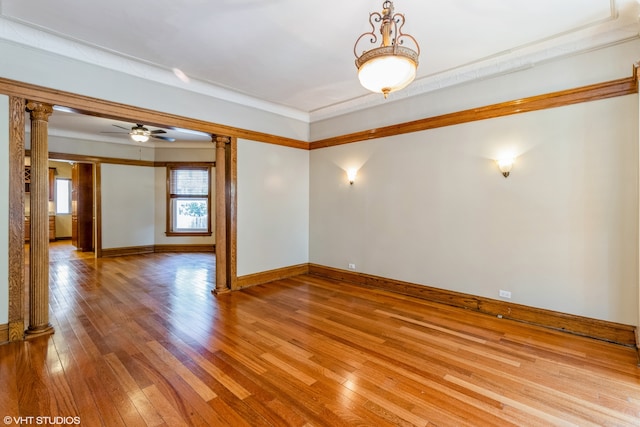 unfurnished room featuring decorative columns, crown molding, light hardwood / wood-style floors, and ceiling fan