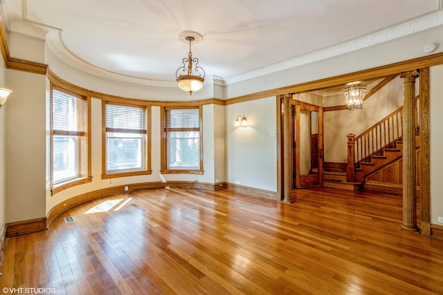 unfurnished room with ornamental molding, hardwood / wood-style floors, and a chandelier