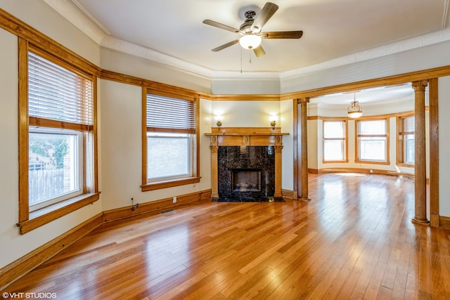 unfurnished living room with ceiling fan, a fireplace, crown molding, and light hardwood / wood-style floors