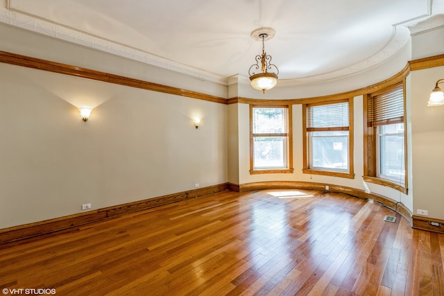 unfurnished room with crown molding and hardwood / wood-style flooring