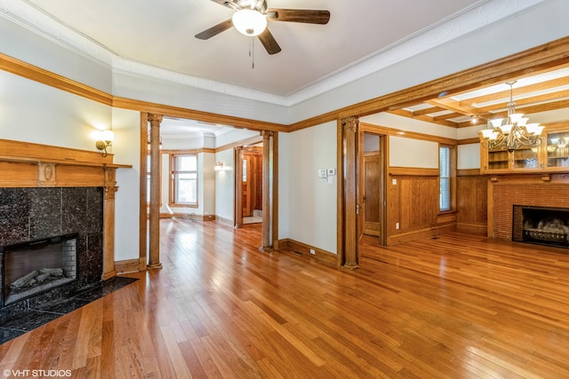 living room featuring beamed ceiling, hardwood / wood-style flooring, ceiling fan with notable chandelier, a fireplace, and ornamental molding