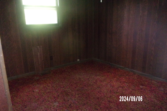 unfurnished room featuring wood walls