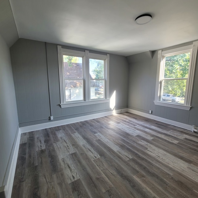 unfurnished room with vaulted ceiling and dark hardwood / wood-style flooring