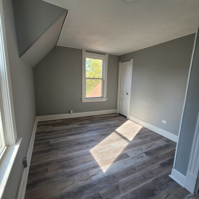 bonus room with vaulted ceiling and dark wood-type flooring