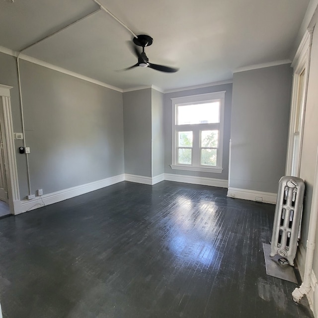 spare room featuring ceiling fan, ornamental molding, heating unit, and dark wood-type flooring