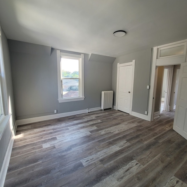 unfurnished room featuring radiator and dark wood-type flooring