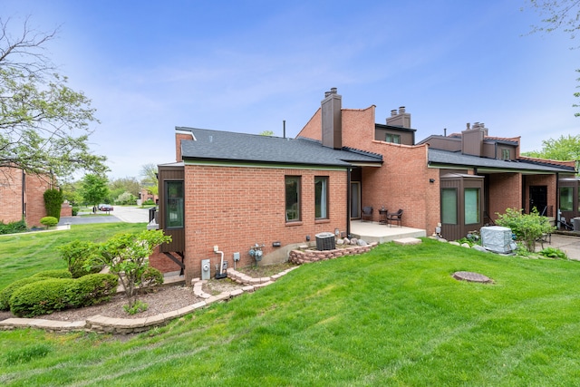 rear view of house with a lawn, a patio, and central AC unit