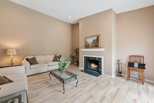 living room with light wood-type flooring and a tile fireplace