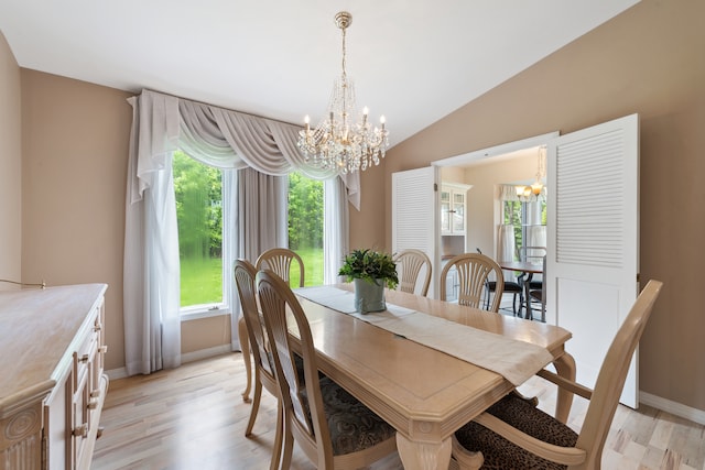 dining room featuring an inviting chandelier, lofted ceiling, and light hardwood / wood-style floors