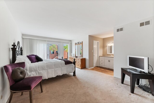 carpeted bedroom featuring ensuite bath