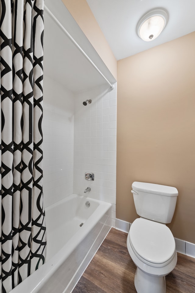 bathroom featuring toilet, hardwood / wood-style floors, and shower / bath combo with shower curtain