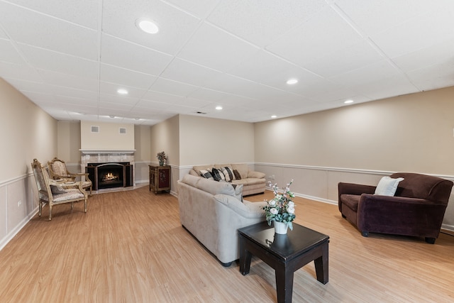 living room featuring a drop ceiling and light hardwood / wood-style floors