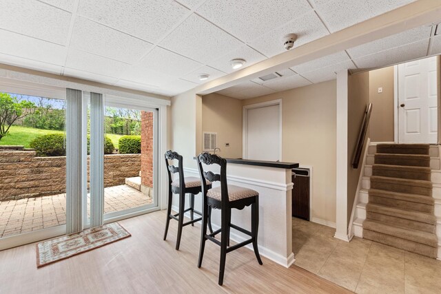 interior space with light tile patterned floors and a paneled ceiling