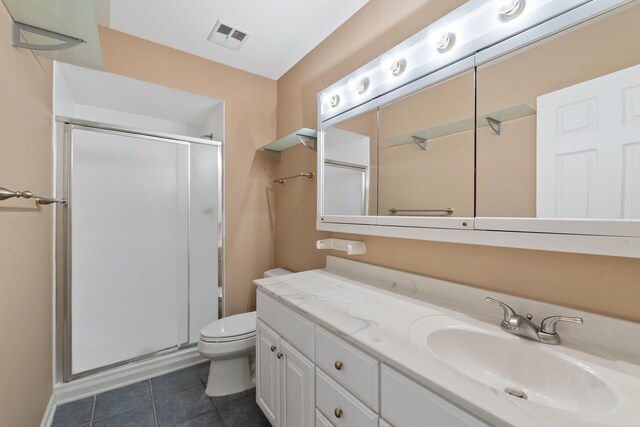 bathroom with vanity, tile patterned flooring, a shower with shower door, and toilet