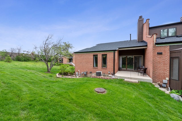 rear view of property featuring central AC unit, a patio area, and a yard