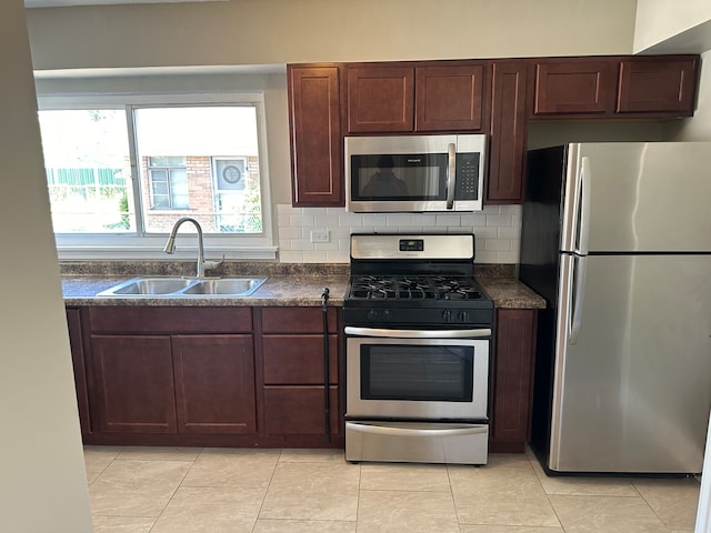 kitchen featuring decorative backsplash, appliances with stainless steel finishes, light tile patterned floors, and sink