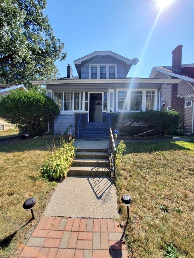 view of front of home featuring a front yard and covered porch