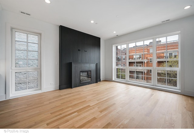 unfurnished living room with light wood-type flooring and a fireplace