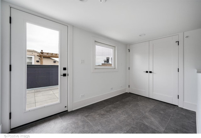 doorway to outside with dark tile patterned flooring