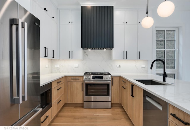 kitchen with sink, pendant lighting, stainless steel appliances, and white cabinets