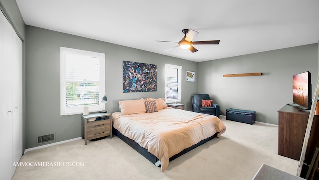 carpeted bedroom with ceiling fan and a closet