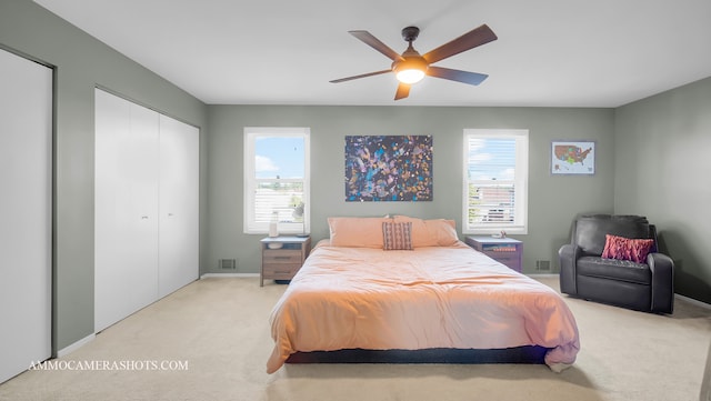 carpeted bedroom featuring multiple windows and ceiling fan