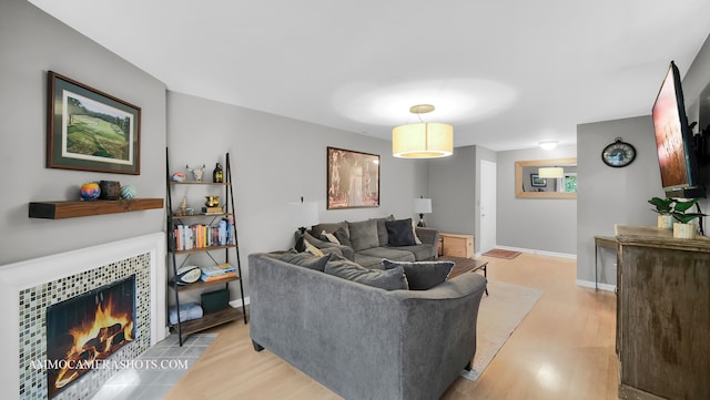 living room with light hardwood / wood-style floors and a tile fireplace