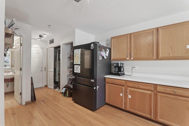 kitchen with light wood-type flooring, smart refrigerator, visible vents, and light countertops