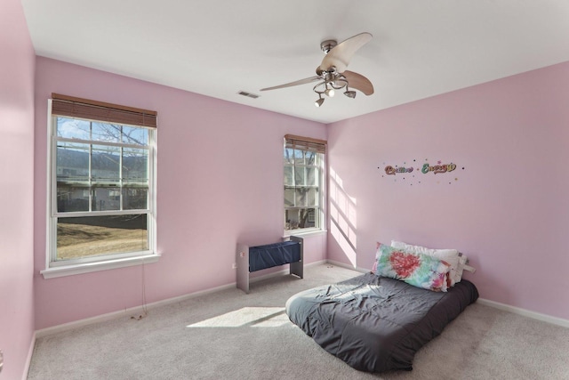 carpeted bedroom with ceiling fan, visible vents, and baseboards