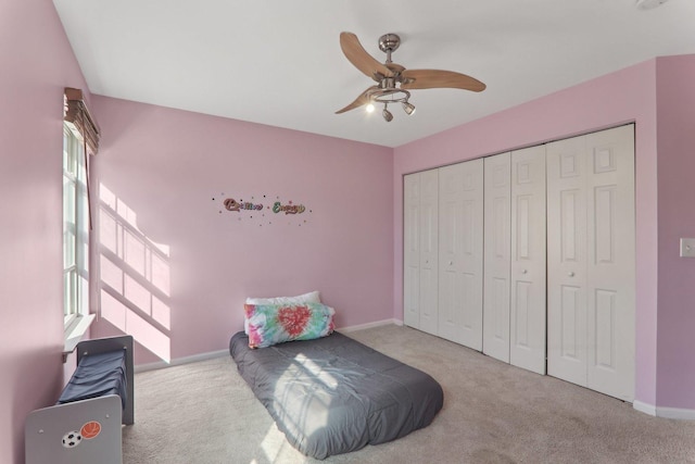 bedroom featuring a ceiling fan, a closet, baseboards, and carpet flooring