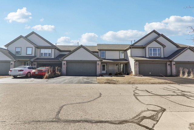 view of front facade featuring a garage, driveway, and brick siding