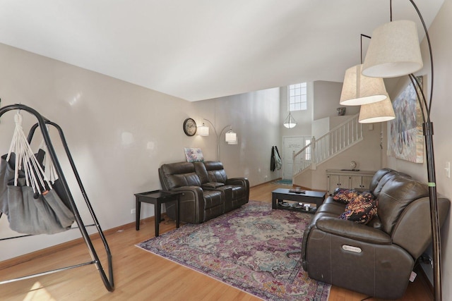 living room with stairs, wood finished floors, and baseboards