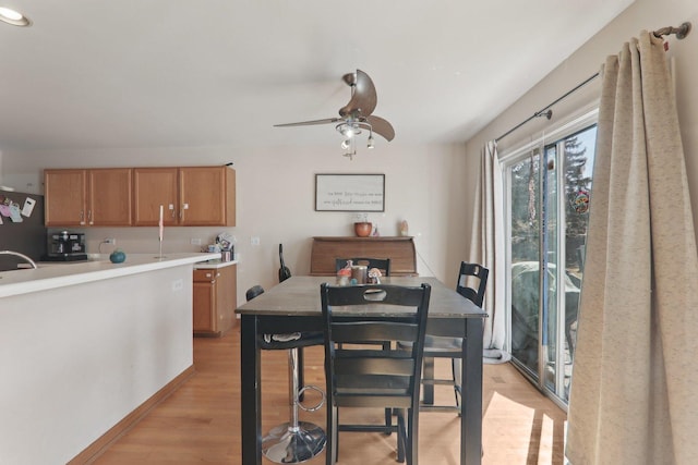 dining area with light wood finished floors and a ceiling fan