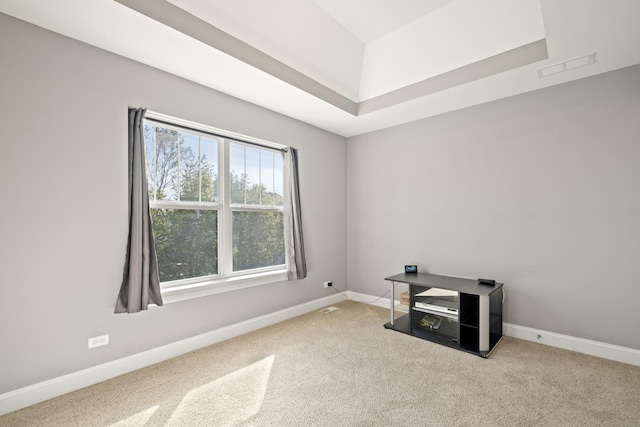 unfurnished room featuring a tray ceiling, carpet floors, visible vents, and baseboards