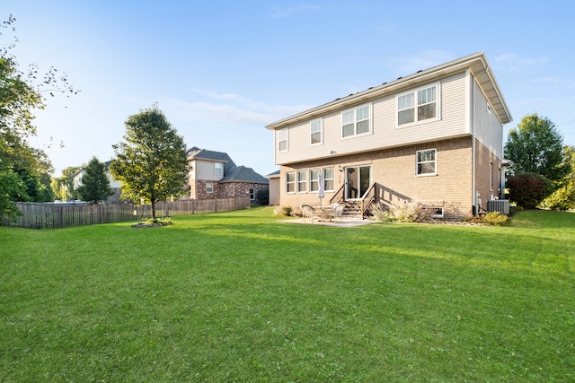 rear view of house featuring cooling unit and a lawn