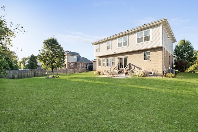 back of property featuring central AC unit, fence, brick siding, entry steps, and a yard