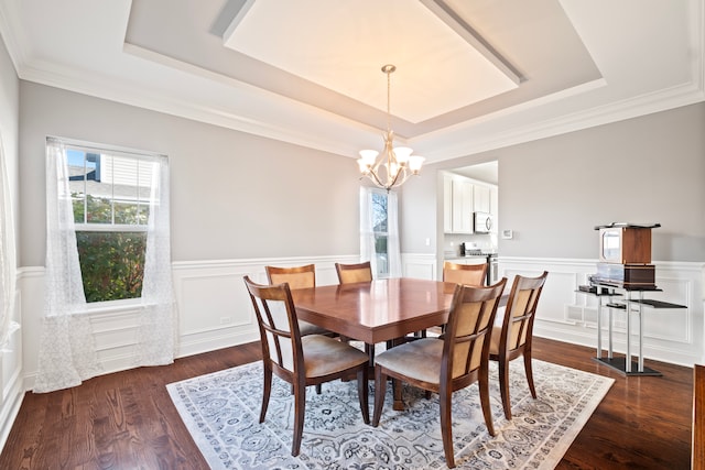 dining area featuring a tray ceiling, crown molding, dark hardwood / wood-style flooring, and a chandelier