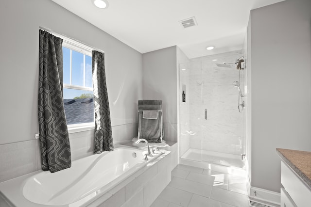 bathroom featuring independent shower and bath, vanity, and tile patterned flooring