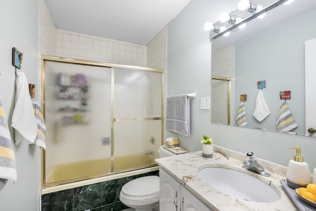 full bathroom featuring enclosed tub / shower combo, vanity, and toilet