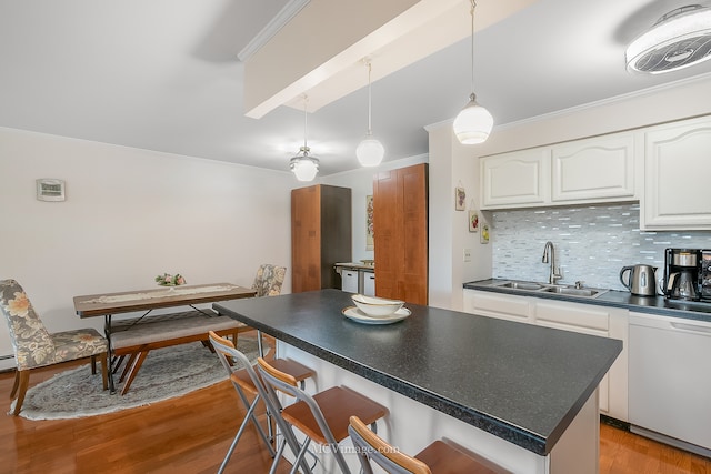 kitchen featuring pendant lighting, sink, tasteful backsplash, white cabinetry, and dishwasher