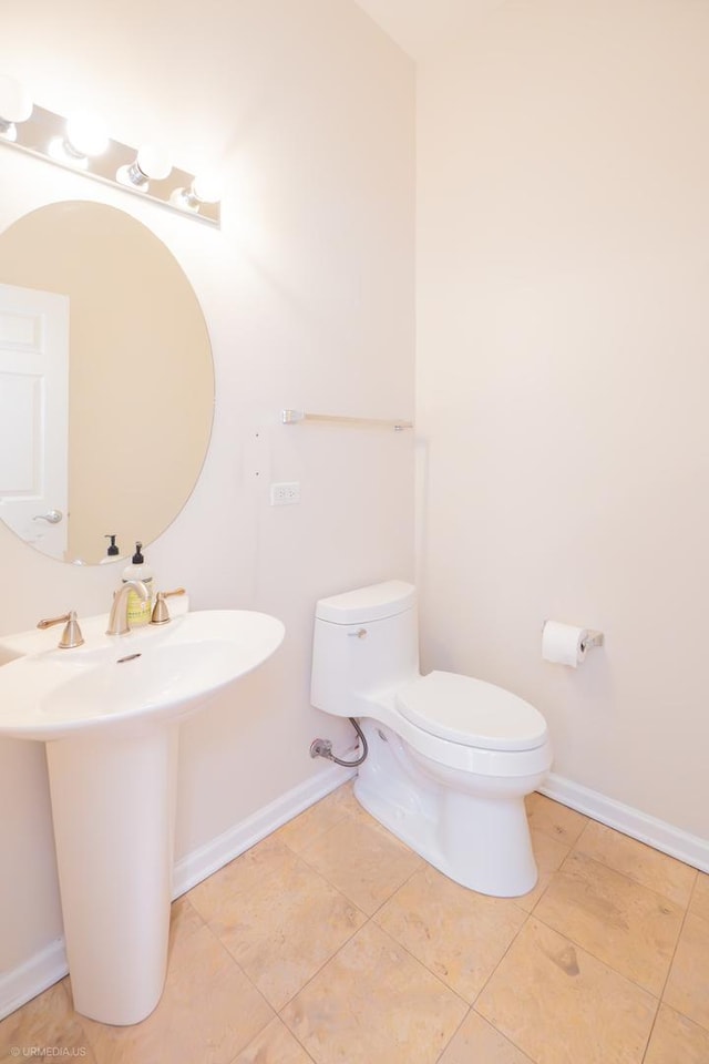 bathroom featuring tile patterned flooring, toilet, and sink