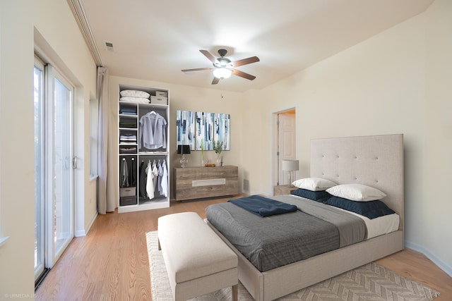 bedroom with ceiling fan, light wood-type flooring, and a closet