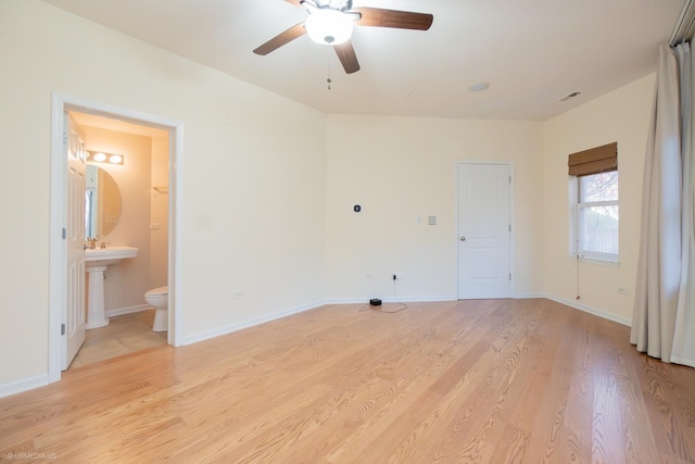 unfurnished bedroom with light wood-type flooring, ensuite bath, and ceiling fan